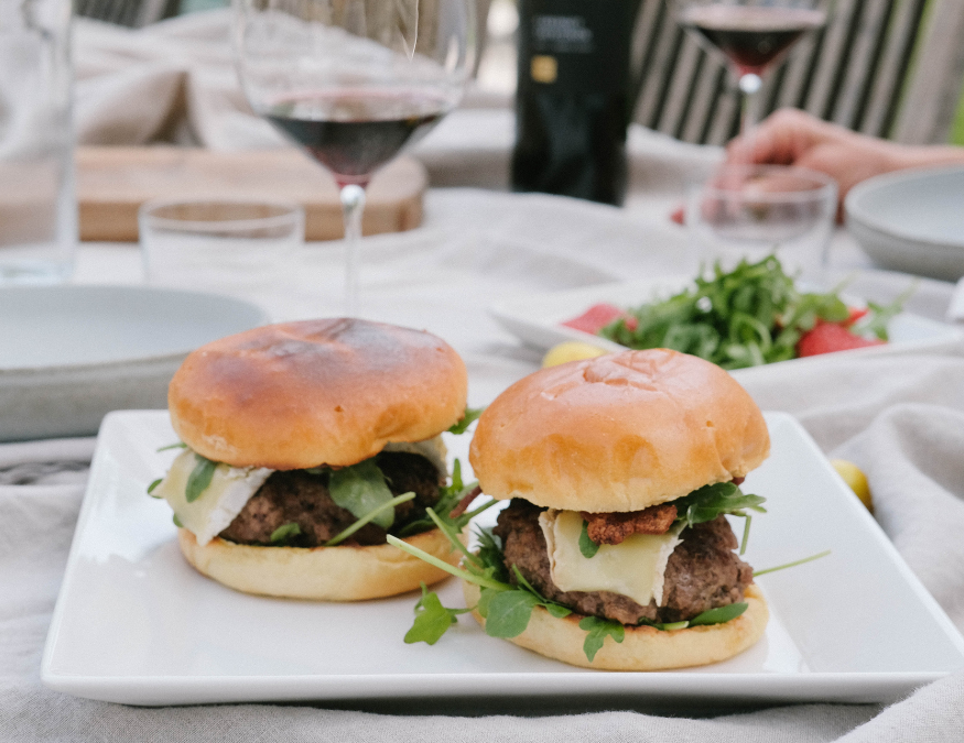 two burgers with glass of wine