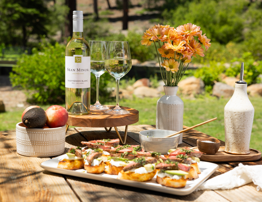 steak crostinis with bottle of sauvignon blanc in background