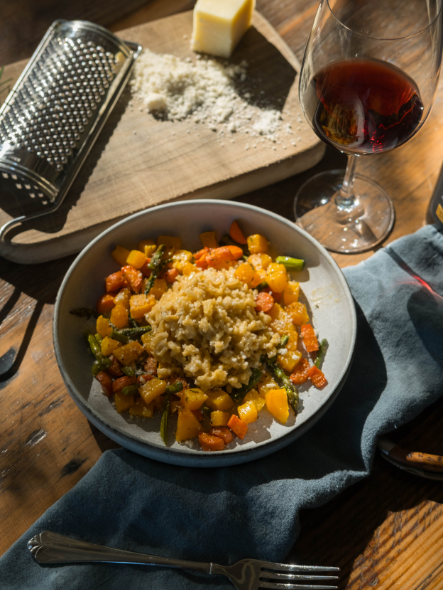 Risotto plated with vegetables glass of wine